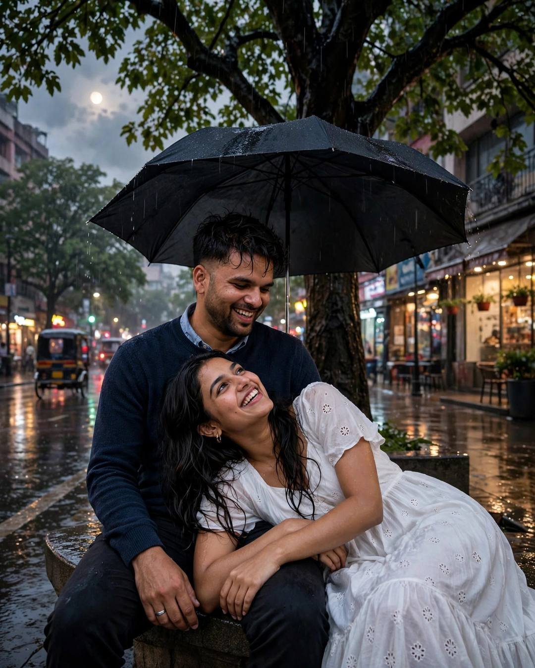 Young Indian couple laughing under one black umbrella on a rain-soaked city street at dusk, woman in flowing white dress, man in navy sweater